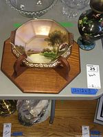 Hand-painted octagonal bowl with landscape scene on wooden wall mount base, held by wooden brackets