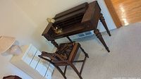 Dark wood desk with hutch and wood framed chair with upholstered seat next to it.