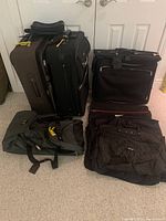 Photo showing 10 assorted luggage items including two upright suitcases with wheels, several carry-on bags, a garment bag, mainly in dark green and black colors.