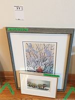 Full view of two framed prints, larger cardinal print behind and smaller potted plant print resting in front