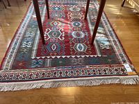 Overall view of rug with geometric medallion pattern and fringe