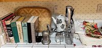 Wide view of kitchen countertop showing vintage cookbooks, rattan serving trays, Bella electric water kettle, Cuisinart stick mixer, kitchen linens, and salt & pepper shakers.