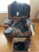 Full set displayed on chair and floor showing coat, vest, tartan kilt, scarf, belt, and matching bag in tartan pattern