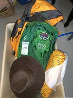 Overview of all items showing the Outback hat, Osprey and Outdoor Products backpacks, and coiled yellow nylon rope