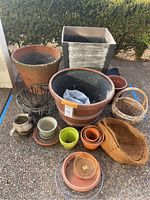 Full group showing terracotta pots, plastic planter, metal baskets, coir liner, small pots and saucers, wicker basket, and metal chains.
