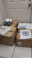 Slippers and folded tops on cardboard boxes by closed door