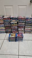 Wide view of large stacks of DVDs and Blu-ray movies arranged vertically and horizontally on floor.