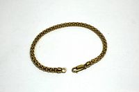 Full length view of gold bead chain bracelet on white background