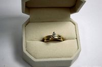 Ring in open box showing front view of band and diamond