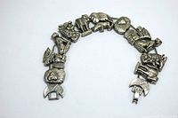Full view of silver tone animal charm bracelet laid flat on white background showing all animal charms and clasp.