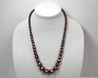 Front view of antiqued copper necklace on display bust, showing graduated round beads and dark antiqued copper finish.