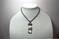 Full view of the silver color metal necklace with pendant displayed on bust stand, showing chain and pendant length and style.
