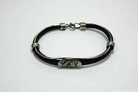 Full view of the black leather bracelet with silver accents and hook closure