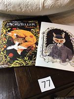Photo of two illustrated books titled 'The Storyteller' with different covers, one featuring a fox holding a bird, the other a fox in a suit with a birdcage.