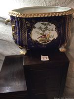Full front view of cobalt blue and gilt porcelain jardinière on wooden surface