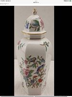 Front view of lidded vase showing floral and bird decoration with gold trim.