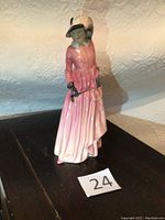 Full view of Royal Doulton Maureen figurine showing standing woman in pink dress with black gloves and hat.