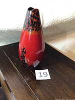 Front side view of the red and black Royal Doulton vase showing color pattern and shape.