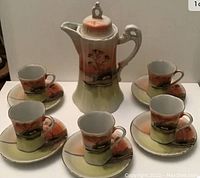 Full set photo showing the chocolate pot, 5 cups and 6 saucers arranged on table