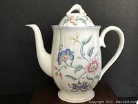 Front view of the porcelain coffee pot showing floral patterns and detailed curved spout and handle.