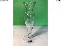 Full view of the hand cut crystal bud vase with green background. Shows shape and size.