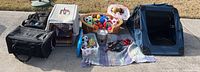 Full lot overview of pet supplies including two plastic dog crates, soft side crate, dog basket, baskets and bin with toys, leashes, and metal treat canister