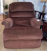 Front view of brown fabric rocking recliner chair with cushioned backrest and padded arms.