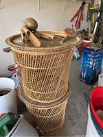 Two stacked rattan wicker side tables with removable glass tops and bamboo wind chimes on top, in garage setting