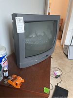 Front side view of Toshiba CRT TV on a wooden dresser, showing the screen and control buttons.