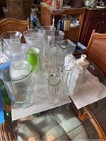 Multiple glass vases arranged on table, varied shapes and styles shown