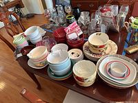 Wide view of table with assorted bowls, dishes, glassware, and napkins displayed
