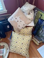 Stack of six throw pillows including bunny design, geometric patterns, and floral prints.