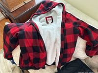 Red and black checkered hooded jacket with white sherpa lining, Mossimo brand, size XL.