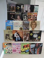 Photo showing front view of various LP vinyl record covers stacked and arranged. Visible artists include Roy Clark, Johnny Mathis, Donny Osmond, Herb Alpert, Chet Atkins, and others. Album covers in a mix of photographic and illustrated styles.