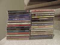 Photo of 30 music CDs stacked in two columns showing various artists and genres including jazz, pop, soul, blues, and compilation albums.