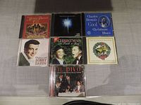 Photo showing 7 Christmas music CDs including artists Bobby Darin, Frank & Bing, Il Divo, Charles Brown, and others.