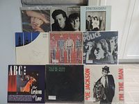 Photo showing all 9 LP records arranged in two rows on carpeted stairs with visible album covers.
