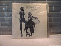 Front cover of Rumours vinyl LP with black and white illustration of band members.