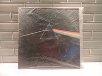 Front cover of Pink Floyd Dark Side of the Moon vinyl record in shrink wrap.