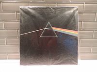 Outer vinyl LP album cover with iconic prism and rainbow artwork in plastic sleeve, showing original shrink wrap condition and light wear.