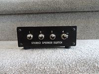 Front view of stereo speaker switch showing four toggle switches and master on/off switch.