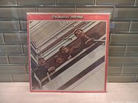 Front cover of The Beatles 1962-1966 LP album showing the band members from an upward angle and red border with text at the top.