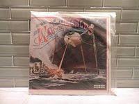 Front view of the vinyl album cover featuring the tripod fighting machine in an ocean battle scene, sealed in plastic.