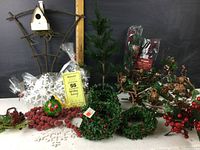 Overview of all holiday decor items together including birdhouse, painted ornament, wreaths, snowflakes, berries, and berry garlands