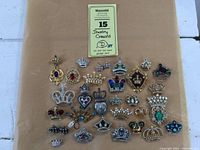 Overview of all costume jewelry crown pins arranged on paper