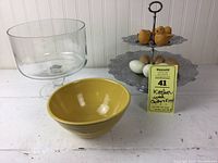 Full view of the yellow mixing bowl, glass trifle bowl, and two-tier metal serving tray with decorative chicks and eggs on top.