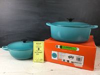 Two Le Creuset pieces displayed with seller note and original seconds box