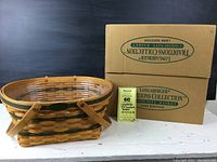 Longaberger 1996 Community Basket along with its original box and a MaxSold tag showing dimensions and lot number.