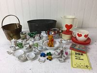 Overview of all miniature items including porcelain crockery, toy cars, teddy bear figure, and larger props.