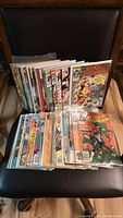 Full lot of comic books arranged in two rows in protective sleeves, featuring visible titles including Transformers and Spider-Man.